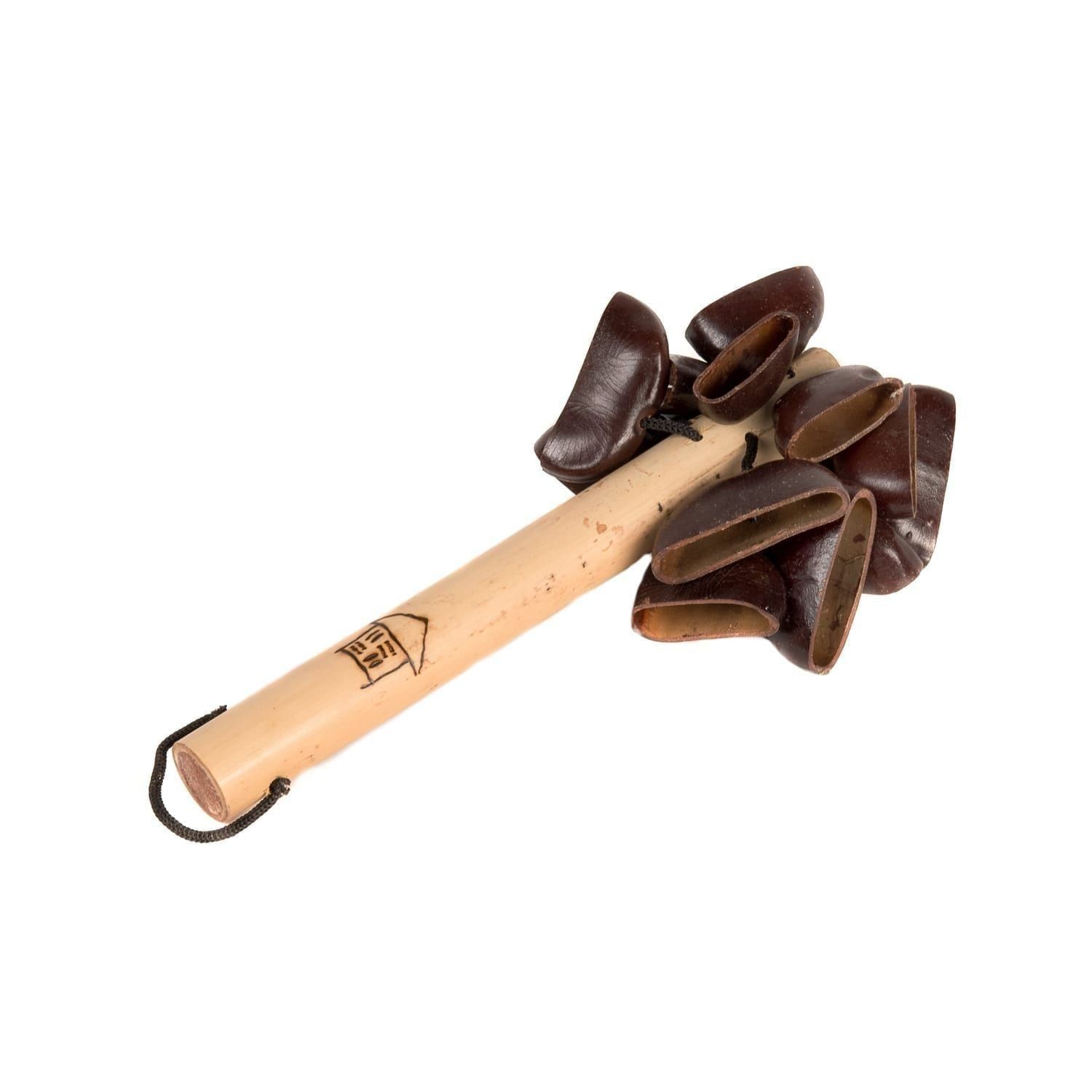 This is a product shot of a Bento Shaker. It has a wooden or bamboo handle with a design burnt into the wood. At the top are many Bento seeds are attached which make the shaker sound.