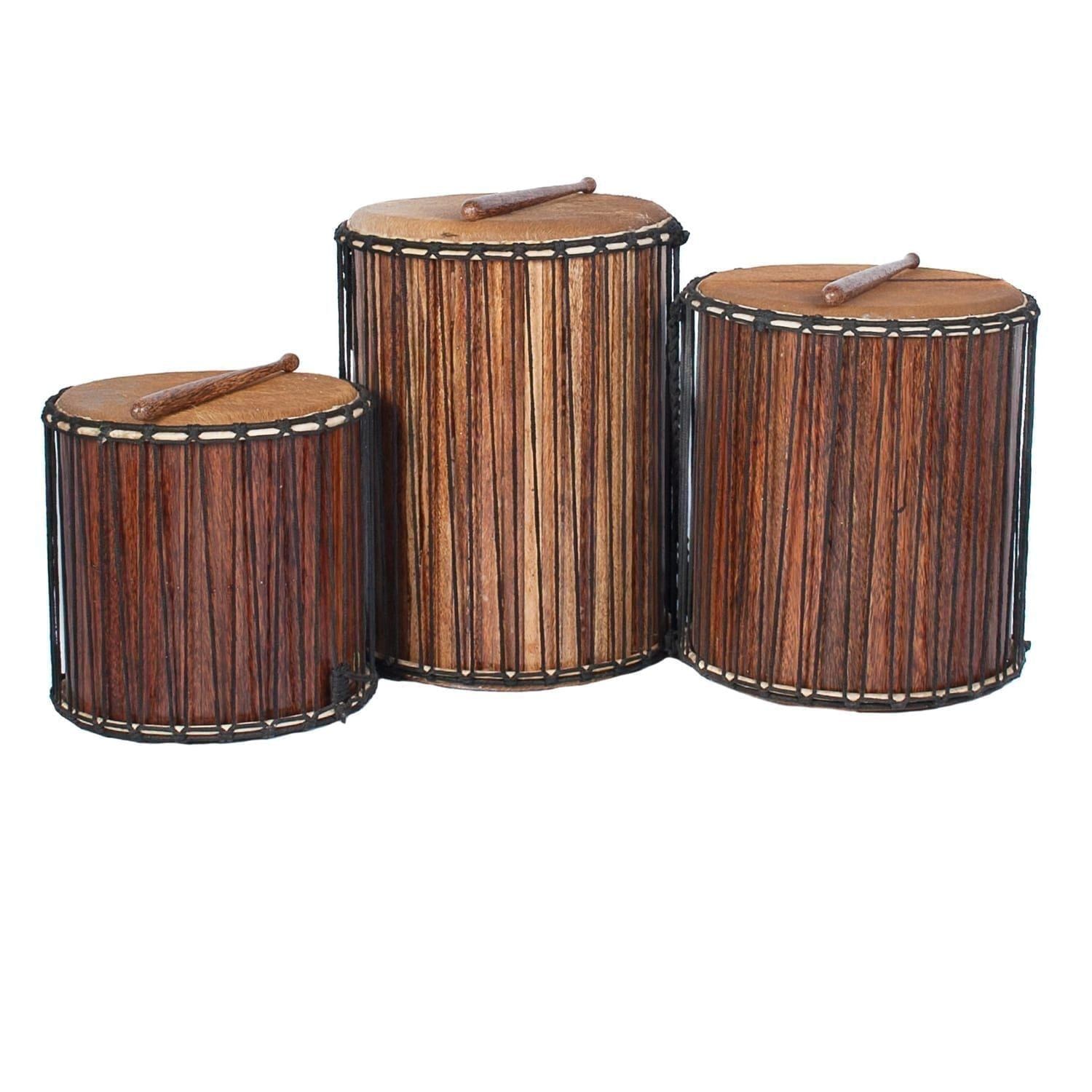 This is a product image of a Dundun Set - Large - recycled wood from the side with a beater resting on each drum. It contains a Kenkeni: 35cm diameter by 40cm high, a Dundun: 45cm diameter by 60cm high and a Sangban: 40cm diameter by 50cm high.