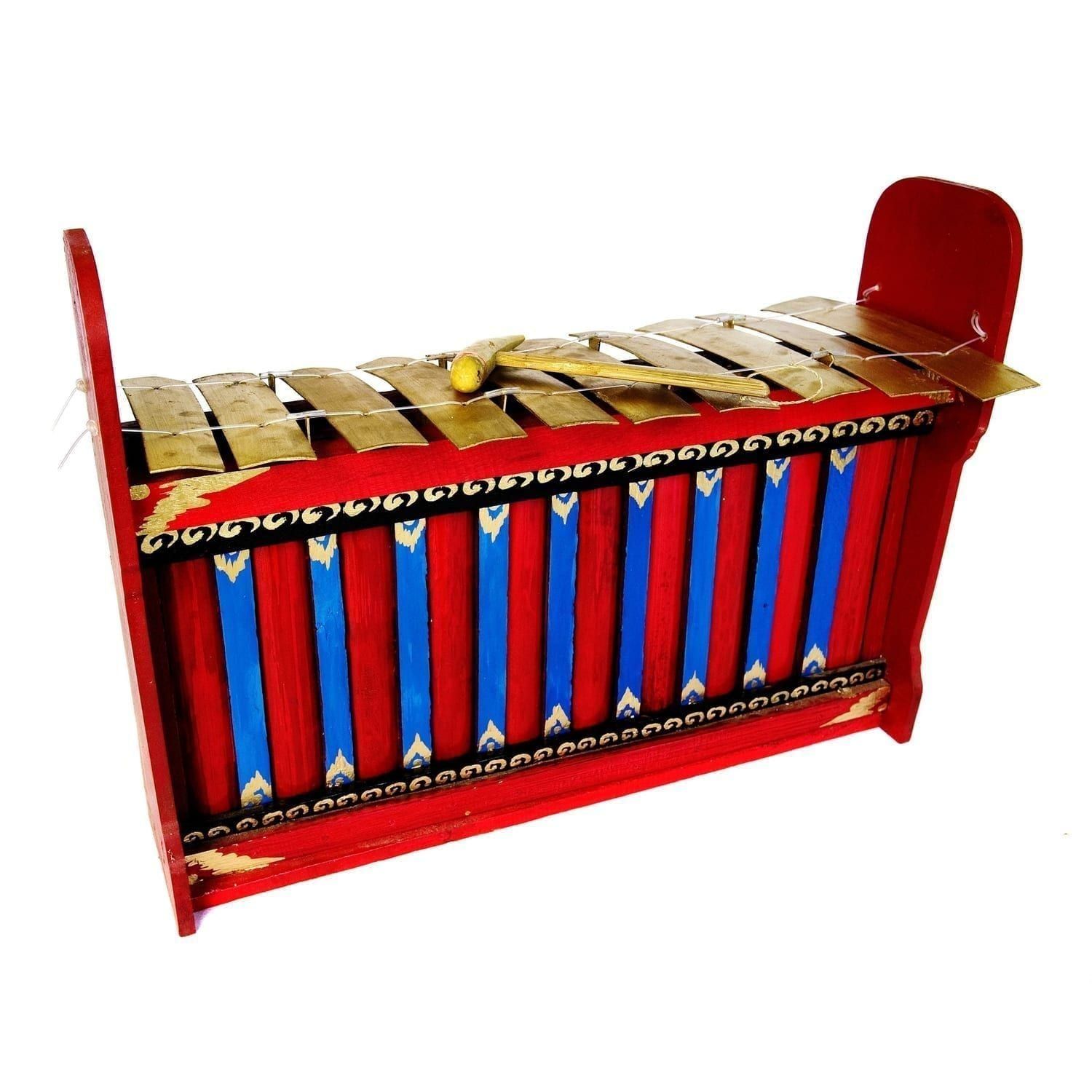 This is a product image of the Gamelan (Gangsa Ugal) - Budget - Large 10 key. The image has been taken from the front and the instrument is facing slightly to the right. It is red and blue with gold keys suspended by wire, and the beater is lying on top of the keys.