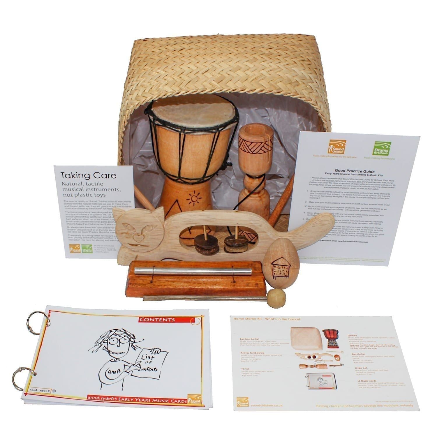 This is a product image of the Home Starter Kit - 5 Instruments. The products are packed into the Storage Basket and include one Djembe Drum - Budget - 4in diameter, 20cm high, Early Years, one Tik Tok - carved, one Egg Shaker - Medium - 7cm, Early Years, one Chime Bar - 1 note, stainless, one Animal Tambourine - Early Years. In front and to the sides are annA rydeR's Music Cards - set of 10, What It's Called + Where It's From Card and a Good Practice Guide.