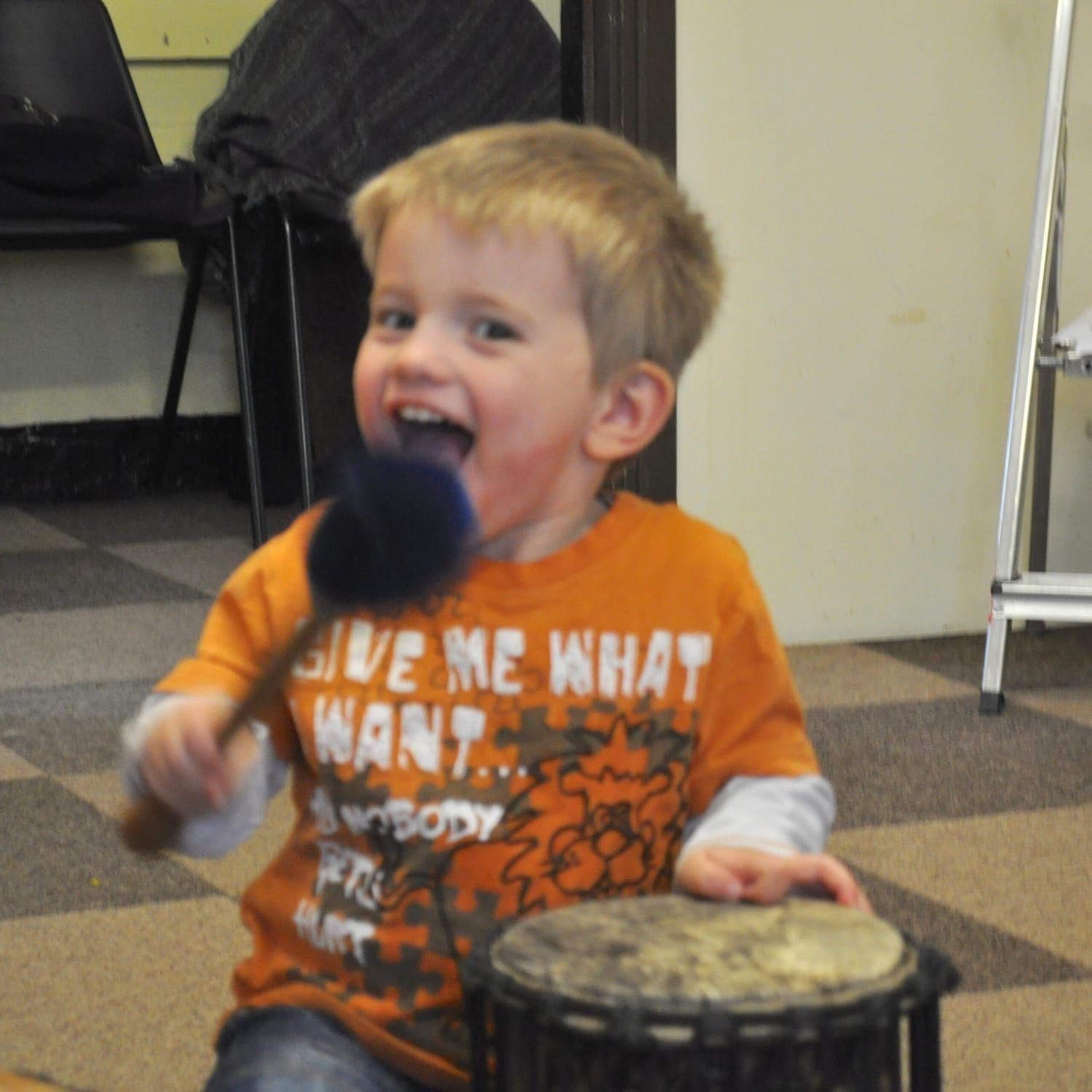 This is an action shot of an Early Years child playing Drums for Schools' Supermini Kenkeni Bamboo