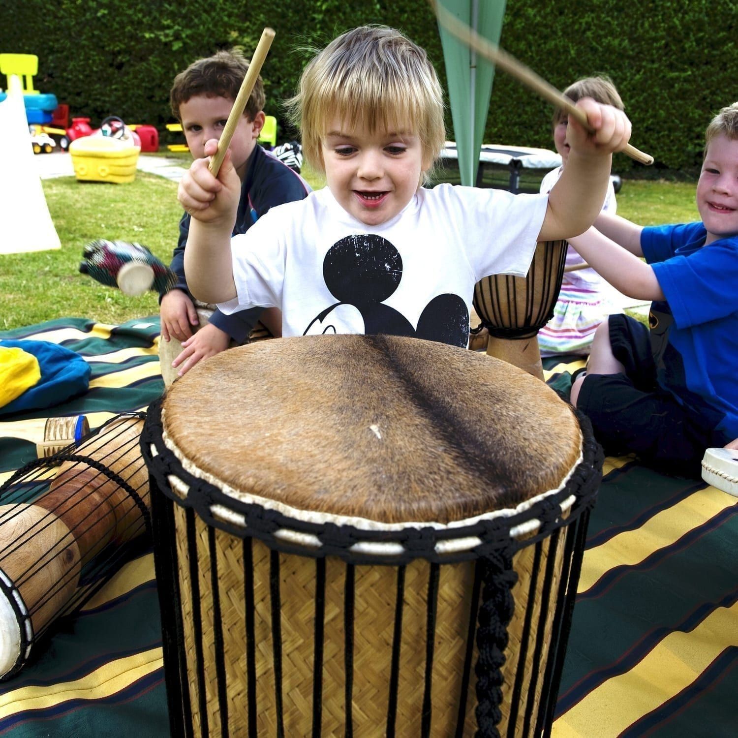 This is an action shot of Early Years children playing Drums for Schools' Kenkeni Bamboo