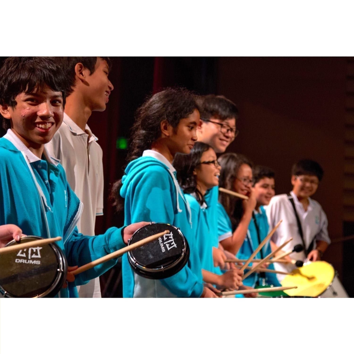 Action shot of students playing Tamborim and Surdo in Nexus School, Malaysia