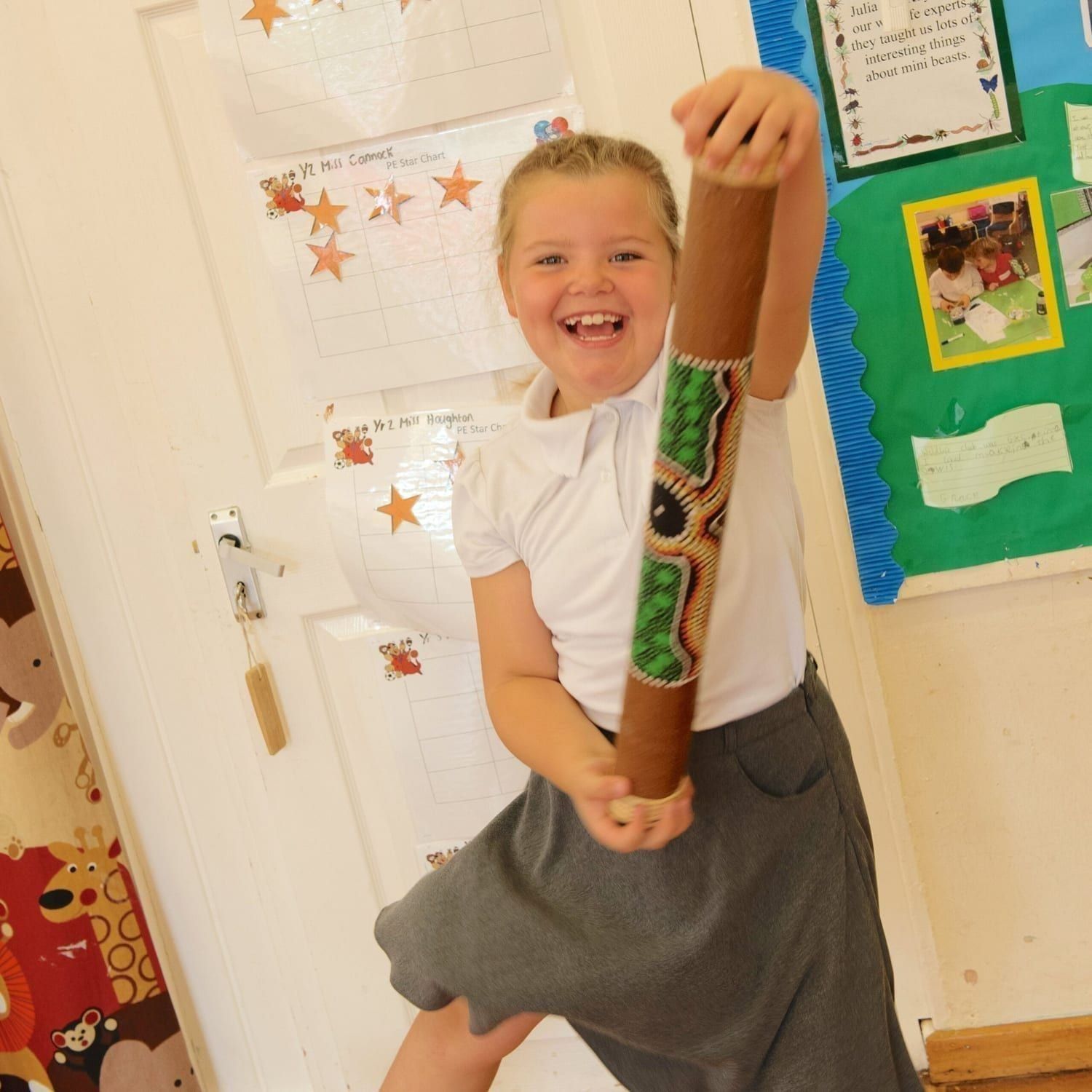 This is a product image of Drums for Schools bamboo rainsticks 80cm, painted, played in action.