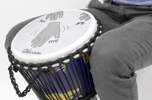 Person playing a Slap Djembe drum with labeled hand positions for slap, bass, and tone techniques, emphasizing educational drumming guidance.