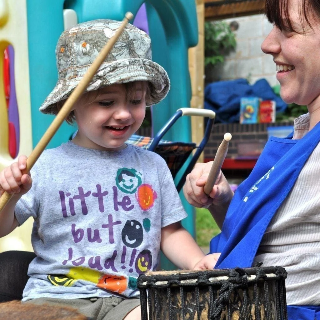 Early Years child playing Drums for Schools' Teeny Weeny Kenkeni Bamboo