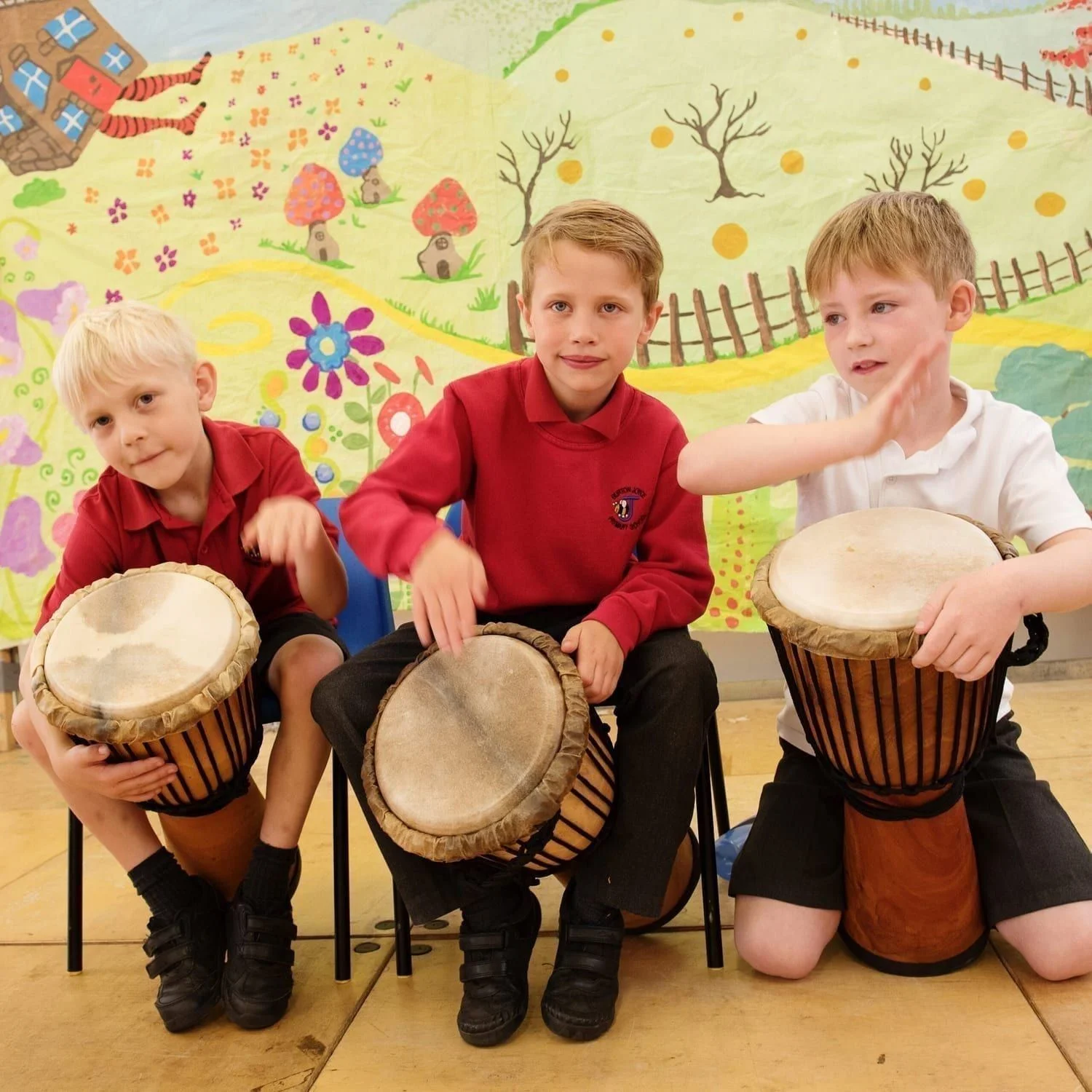 Primary school children playing djembe drums